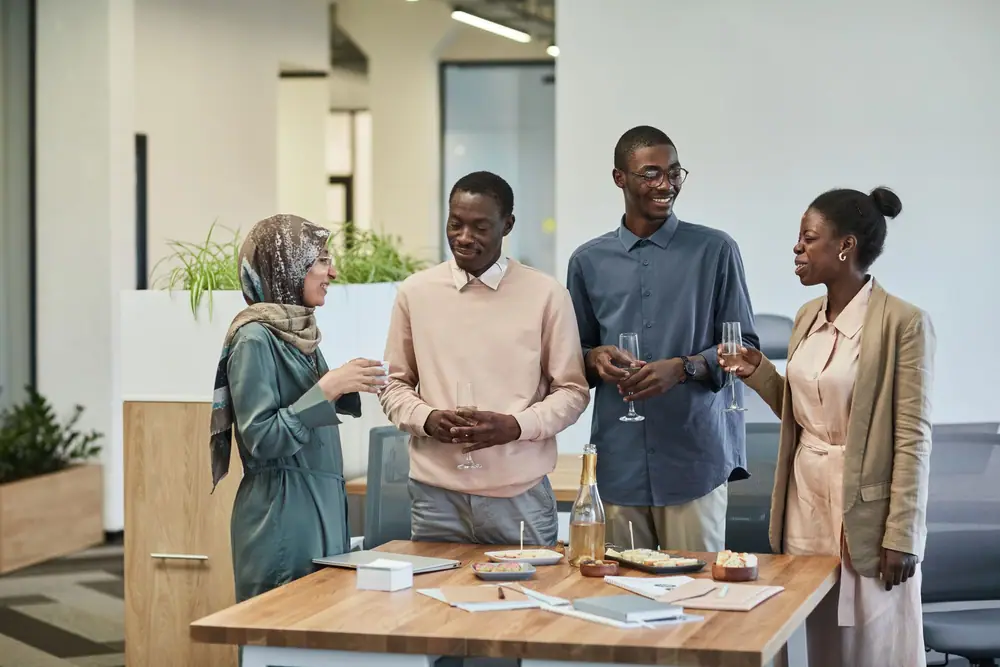 A small group of adults chatting and smiling around a table