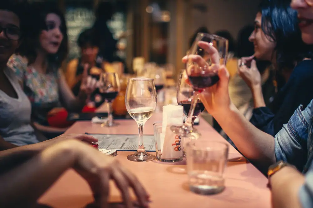 Friends sharing drinks and conversation around a table during an evening get-together